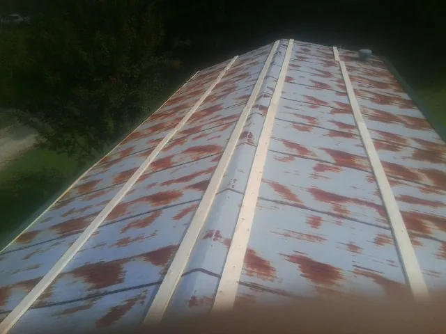 Rusted metal roof panels with new wood purlins before replacement — Storm Damage Roof Repair in Kiel by Roofing Brothers