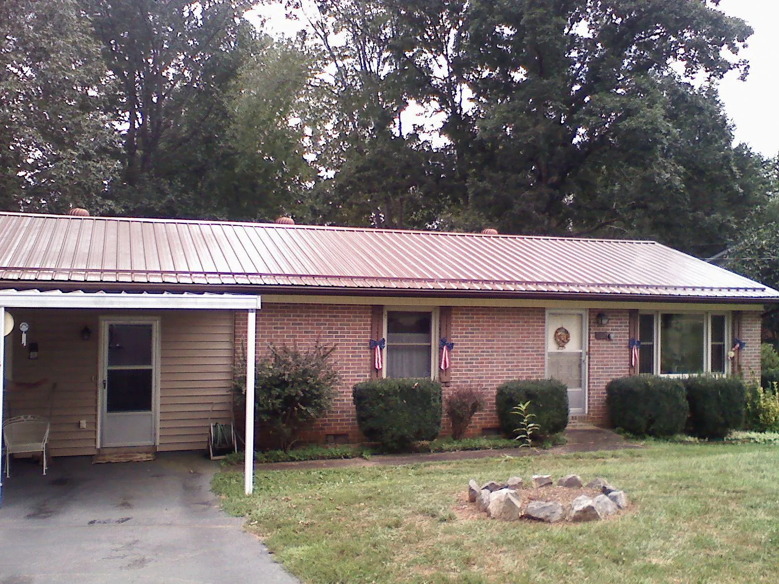 Bronze metal roof and carport on a brick ranch home — Roof Repair work by our crew in Kiel
